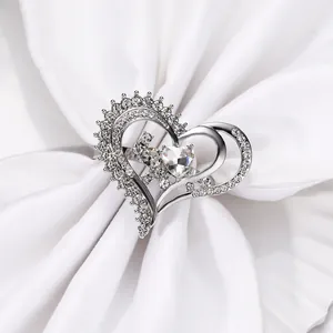 Macro detail of silver napkin ring with hollow heart design and sparkling rhinestones