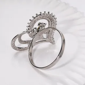Silver rhinestone hollow double heart napkin ring on a white textured ceramic plate