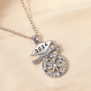 Macro detail van 2024 afstudeerketting met kompas en afstudeerhoed hanger