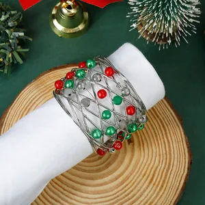 Silver mesh Christmas napkin ring with red and green beads on a white napkin