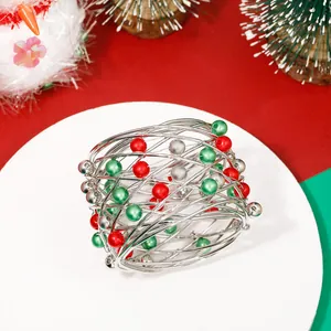 Detailed view of silver wire Christmas napkin ring with festive red and green beads