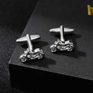 Detailed close-up of silver motorcycle cufflinks on a premium black gift box texture