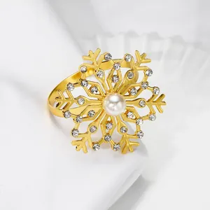 Vue détaillée du rond de serviette flocon doré avec perle blanche et strass étincelants