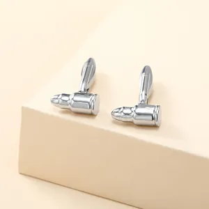 Detailed view of silver bullet-shaped cufflinks with a polished mirror finish on a pedestal