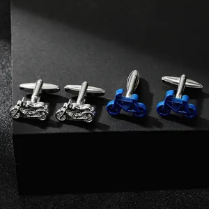 Close-up of silver motorcycle and blue bicycle cufflinks on black textured display