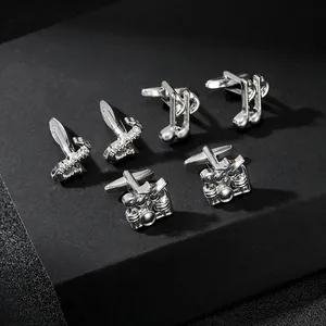 Detailed macro of silver music instrument cufflinks including saxophone and drum designs