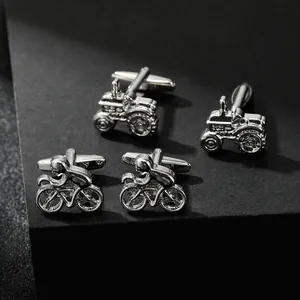 Detailed macro shot of silver tractor and cyclist cufflinks on black display stand