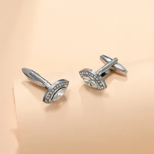 Macro shot of silver cufflinks featuring a marquise-cut zircon with micro-pave detailing