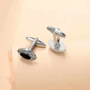 Detail of silver-tone marquise cufflinks with black stone and pavé crystal accents