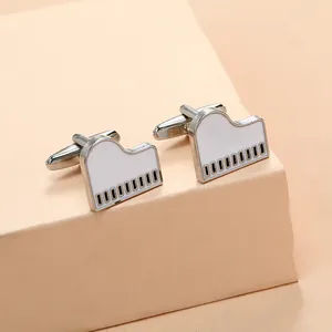 Close-up of piano cufflinks with white enamel finish and black keys on geometric stand