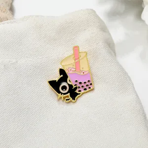 Close-up of a cute black cat and bubble tea enamel pin on a white canvas bag