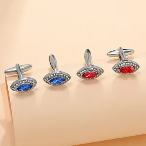 Macro shot of marquise-cut zircon cufflinks in red and blue with silver T-clasp