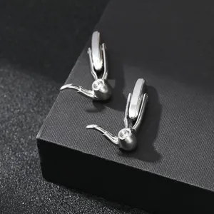 Macro shot of polished silver pipe-shaped cufflinks with crystal inlay on black jewelry box