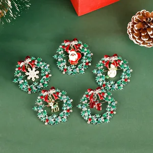 Detail of Christmas wreath brooches with reindeer and santa pendants and rhinestones