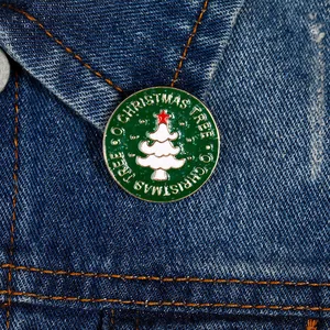 Detail van kerstboom emaille speld met glitter op een blauwe spijkerjasje