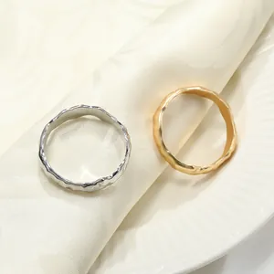 Ronds de serviette élégants en or et argent avec texture martelée sur plateau blanc