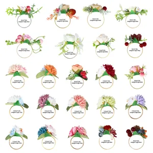 Sortierte Serviettenringe mit künstlichen Blumen Beeren und Blättern im Detail