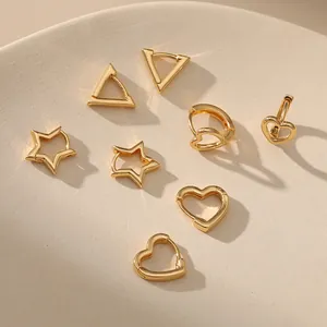 Detailansicht goldener hohler Herz- und Geometrie-Ohrringe auf einem Kunstsockel