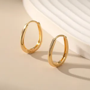 Detailansicht goldener Metallohrringe in Tropfenform mit glatt polierter Oberfläche