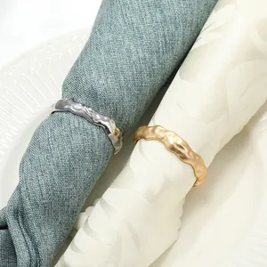 Ronds de serviette élégants en métal doré et argenté avec texture martelée sur assiette