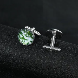 Detail view of round silver cufflinks with vintage daisy motif on a black display roll