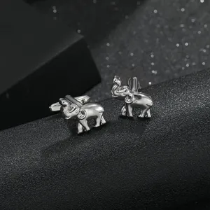 Polished silver elephant cufflinks for men on a dark textured background