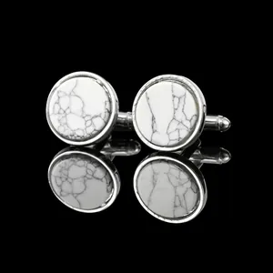 Detailed macro view of silver-toned round cufflinks with white marble stone inlay