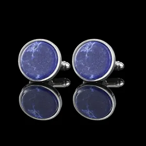 Close-up of classic round silver cufflinks with deep blue marbled stone and reflections