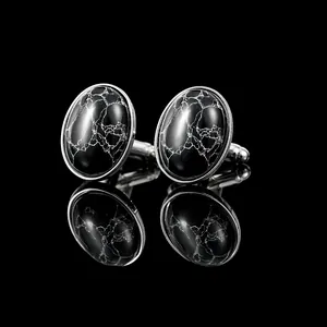 Detailed view of silver oval cufflinks with elegant white marble texture and black finish