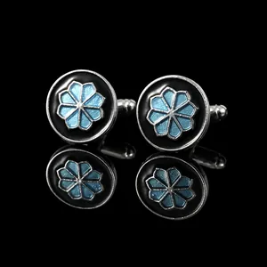 Polished silver alloy cufflinks with black enamel and blue floral pattern on black background