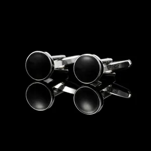 Macro shot of silver cufflinks with black round inlay and elegant bullet back closure