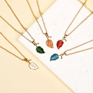 Detail showing five colorful enamel leaf pendants on gold-tone thin chains