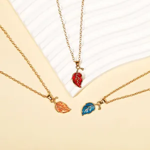 Close-up of leaf pendants in red, orange and blue enamel with gold chains