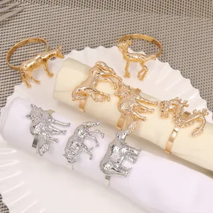 Servilleteros de metal dorado y plateado con relieves de animales como caballo y lobo