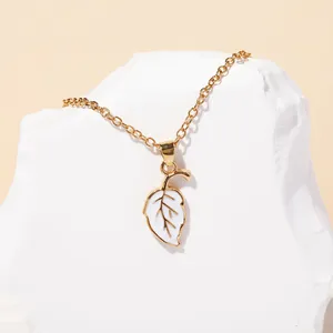 Macro detail of leaf pendant featuring white oil drop inlay and golden metal edges