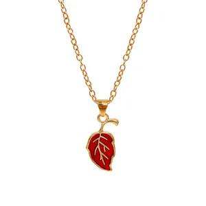 Detailed close-up of golden chain necklace featuring a vibrant red leaf pendant