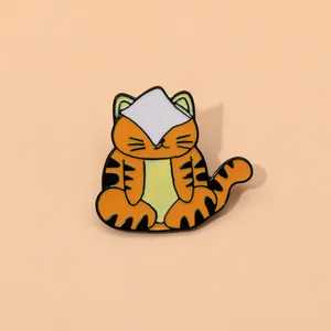Détail d'un pin's émaillé en forme de tigre mignon aux rayures orange et noires vives