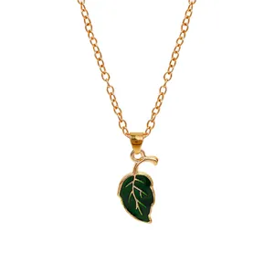 Minimalist gold leaf necklace with green enamel pendant on a clean white background