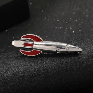 Macro view of rocket shaped silver metal tie clip with red enamel fin details
