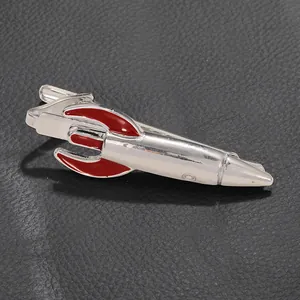 Close-up of a silver rocket shaped tie clip with red enamel details on black leather