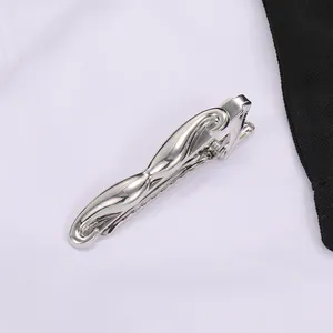 Pince à cravate argentée en forme de moustache sur cravate noire et chemise