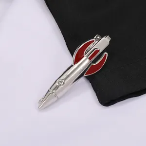 Detailed close-up of a silver rocket tie clip with vibrant red enamel on suit fabric