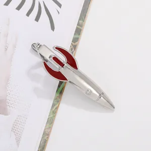 Close-up of a silver rocket tie clip with red enamel details on a magazine background