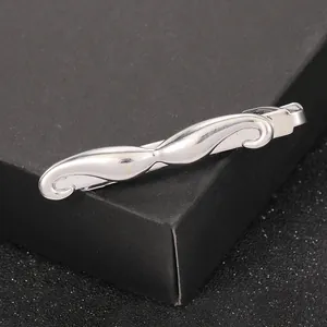 Gros plan d'une pince à cravate moustache en métal argenté poli sur boîte à bijoux