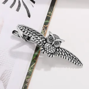 Detail view of a vintage silver owl necktie clip featuring intricate feather textures