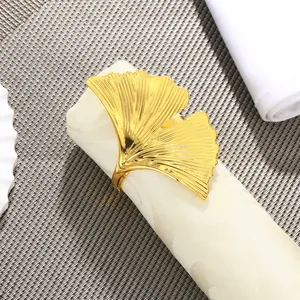 Dettaglio ravvicinato di un portatovagliolo a foglia di ginkgo dorata con texture