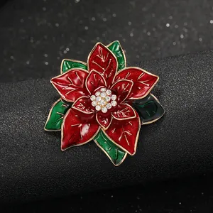 Detail der rot-grünen Emaille-Weihnachtsstern-Brosche mit funkelnden Kristallen