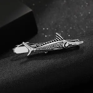 Macro view of vintage silver sailfish tie clip showing intricate metallic texture