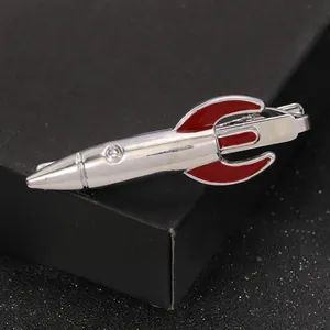 Silver rocket tie clip with red enamel tail on star-textured display stand