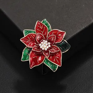 Eleganter roter Weihnachtsstern-Brosche mit Goldrand und Kristallmitte auf schwarzem Grund